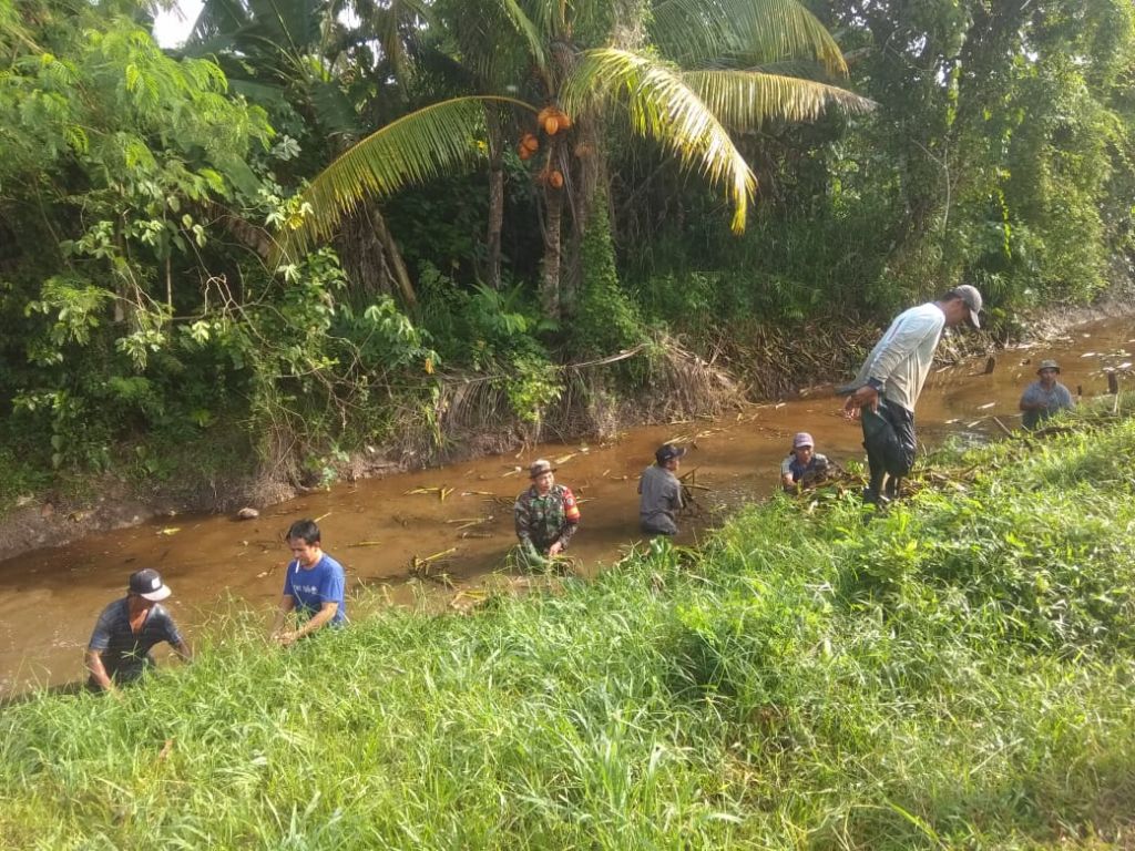 Bangun Budaya Gotong Royong, Babinsa Sungai Rasau Bersihkan Aliran Sungai