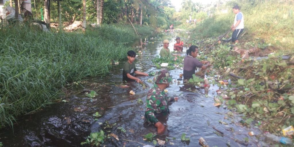 Babinsa Bersama Masyarakat Gotong Royong Bersihkan Sampah di Aliran Sungai