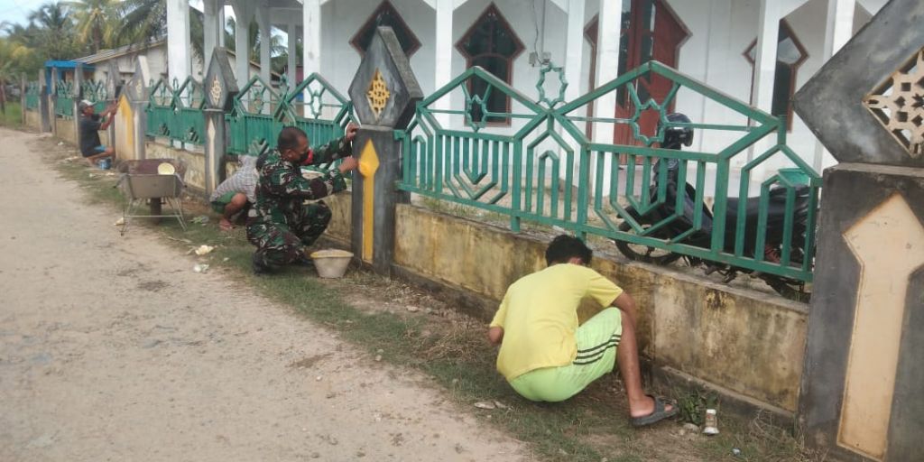 Peduli Dengan Rumah Ibadah, Babinsa Bersama Masyarakat Gotong Royong Cat Pagar Masjid